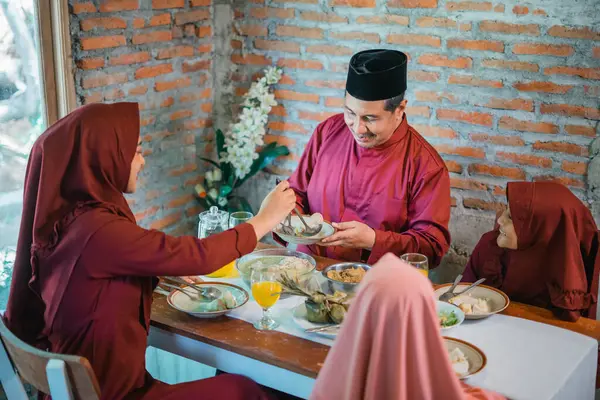 Bir aile masanın etrafında toplanıp geleneksel yemeğin tadını çıkarıyor ve birlikteliklerini vurguluyor.