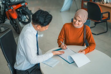 Satıcı, yeni motosiklet alıcısına motosiklet galerisindeki onay mektubunu tamamlaması için talimat verdi.