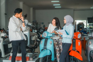 Eşim yeni bir motosiklet deniyor. Kocasıyla ve tezgahtarıyla.