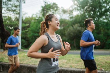 Kadın spor giyim maratonunda tutkuyla koşuyor.