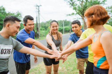 Asyalı sporcu ellerini takım olarak birleştiriyor.