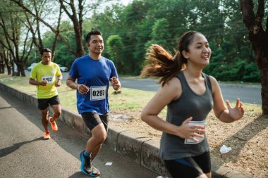 Spor giyimli atletik erkek maratonda koşuyor.