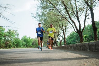 Maraton yarışması için yolda koşan maratoncu