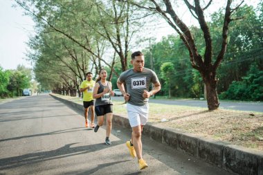 Asyalı atlet tutkuyla maratonda koşuyor.