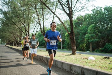 Maratonda koşan Asyalı erkek sporcu