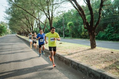 Maraton koşucuları maratona katılarak yolda koşuyorlar.