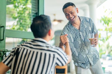 İki arkadaş kafeteryada sıcak bir karşılama yapıyorlar.