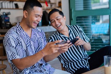 İki arkadaş, modaya uygun ve şık bir kafede keyifli bir oyun seansı yapıyorlar.