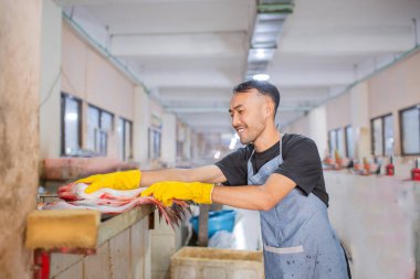 Kendini işine adamış bir işçi, karmaşık deniz ürünlerini özenle ve titizlikle hazırlar.