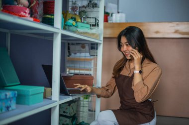 Asyalı kadın mağaza görevlisi aradı ve bir hediyelik eşya dükkanının rafında bir laptop görmüş.