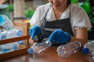 Ekin manzaralı kadın, el işi yapmak için boş plastik şişeyi tekrar kullanıyor.