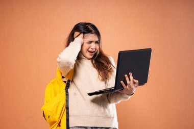 Genç bir kadın dizüstü bilgisayarı üzerinde çalışırken hayal kırıklığını açıkça ifade ediyor.