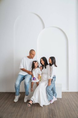 Dört kişilik bir aile, odaların atmosferini arttıran düz beyaz bir duvarın önündeki rahat koltukta rahatça oturuyor.