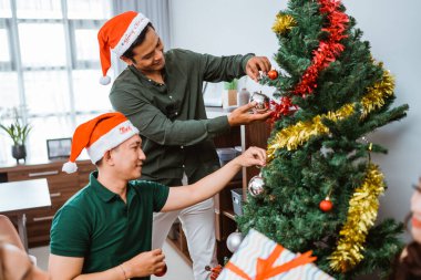 İki yakın arkadaş güzel Noel ağaçlarını süsleyerek bayram mevsimini kutluyorlar.