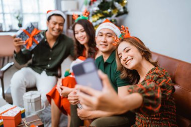 Arkadaşlar Noel 'i kutlamak için neşeyle toplanır, birlikte kahkaha ve mutluluk paylaşırlar.