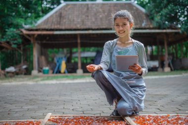 Sakin bir açık hava ortamında, genç bir kadın canlı malzemelerle ustalıkla yaratıyor.