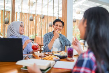 Üç öğrenci bir kafede yemek ve içeceklerin tadını çıkarırken birlikte öğrenirler.