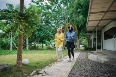 İki genç kadın enerji ve neşe dolu canlı bir ortamda birlikte geziniyorlar.