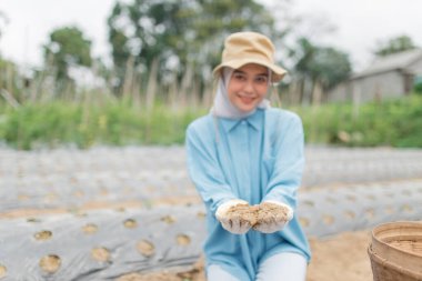 Bereketli bir çiftlik ortamında, neşeli bir kadın zengin toprakları elinde tutar, doğaya olan aşkını kutlar