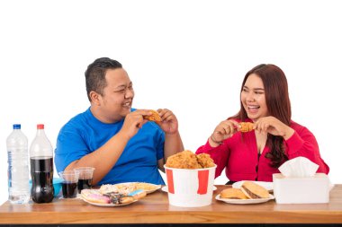 Mutlu bir çift, kahkahalarla dolu lezzetli bir fast food yemeğinin tadını çıkarır.