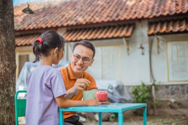 Gülümseyen Asyalı baba kızıyla dışarıda vakit geçiriyor.