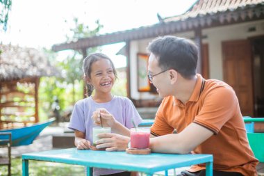 Neşeli kız Asyalı babayla birlikte boş zamanlarında gülüyor.