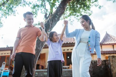 Genç Asyalı ebeveynler kızlarıyla eğleniyor.