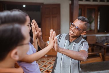 Mutlu büyükbabanın torunuyla beşlik çakışının yakın görüntüsü.