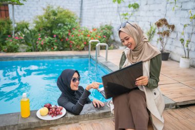 Arkadaşlar havuz başında toplanır, neşeyle abur cubur ve kahkahayı paylaşır, yaz ruhunu somutlaştırırlar.