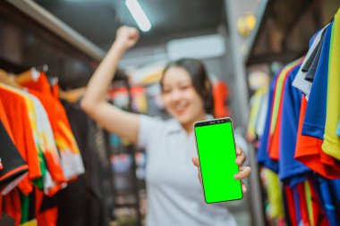 female worker holding mockup phone with fist pump gesture for celebration clipart