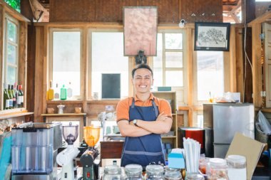 Kendine güvenen garson kolları çapraz duruyor.