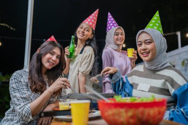 Neşeli ve canlı bir parti sahnesi. Arkadaşların birlikte sevinçle kutladığı.