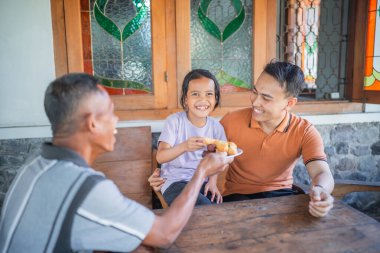 Heyecanlı genç çocuk büyükbabasından atıştırmalık ikram etti, aile kavramı.