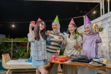 Dostlar neşeli bir açık hava partisinin tadını çıkarırlar şenlikli şapkalar ve içten kahkahalarla dolu