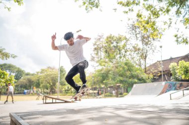 Yetenekli bir kaykaycı, parlak, güneşli bir kaykay parkında etkileyici yetenekler sergiliyor.