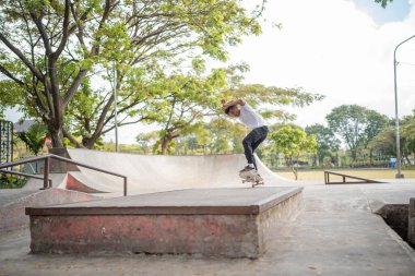 Canlı bir açık hava parkı ortamında dinamik ve heyecan verici kaykay eylemi