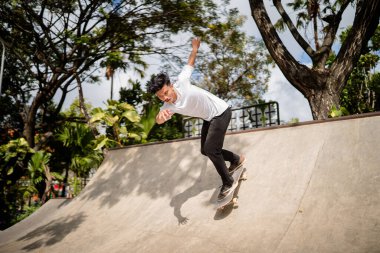 Genç bir kaykaycı, yerel bir kaykay parkında etkileyici yetenekler sergiliyor.