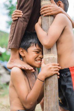 Çocuklar, bağımsızlık kutlamaları sırasında arkadaşlarının omuzlarına binen yükü taşıyorlar.