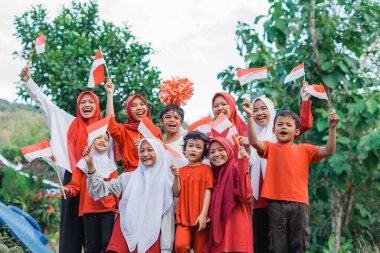 Türbanlı kadın destekçiler ve Endonezya bayrakları taşıyan erkekler yarış takımını destekliyor.