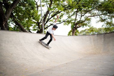 Becerikli bir kaykaycı paten yapmak için tasarlanmış pürüzsüz, geniş bir beton kasede numaralar yapar.