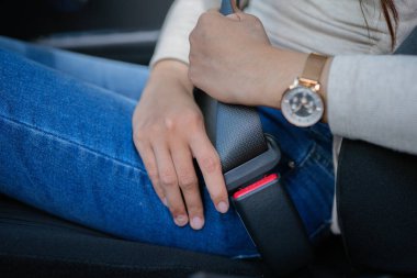 A woman fastening her seatbelt, highlighting the importance of road safety and responsible driving clipart