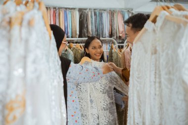 Üç arkadaş şık bir butikte şık elbiseler almak için keyifli bir günün tadını çıkarıyorlar.