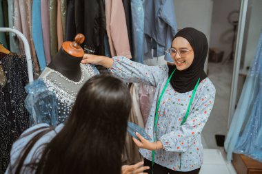 Yetenekli kadınlar, canlı bir butikte eşsiz moda tasarımları üzerinde çalışırlar, yaratıcılıklarını sergilerler.