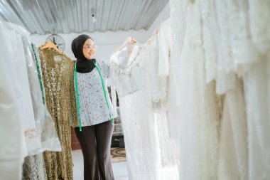 Yetenekli bir tasarımcı şık bir butikte bir dizi güzel beyaz elbise sergiliyor.