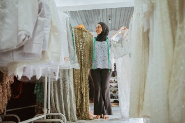 Bir kadın canlı bir giyim mağazasından güzel bir geleneksel kıyafet seçer.