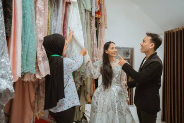 Müşteriler şık bir butikte eşsiz bir deneyime sahip zarif gelinlikleri heyecanla keşfediyorlar.