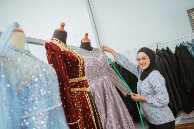 Yetenekli bir tasarımcı güzel bir elbiseyi canlı bir stüdyoda ayarlar ve mükemmel bir uyum sağlar.