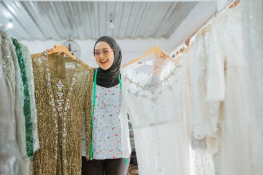 Olağanüstü mutlu bir kadın gururla güzel ve canlı geleneksel elbiseler sergiliyor.