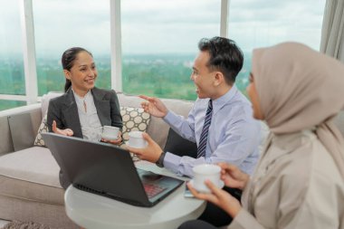 Modern bir ofiste, takım üyeleri birlikte çalışır ve yenilikçi fikirleri aktif olarak tartışırlar.
