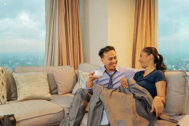 Mutlu bir çift şık bir oturma odasında çaylarını yudumlarken keyifli bir an geçirir.